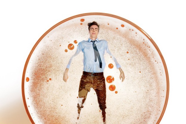 Someone floats on their back in an alcoholic beverage