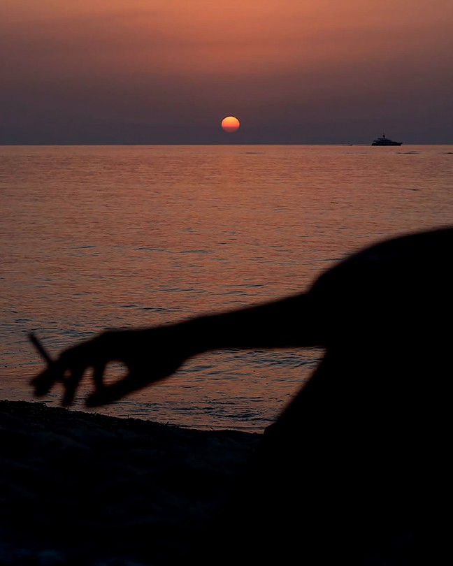 image of a sunset on a lake with a figure in the shadow