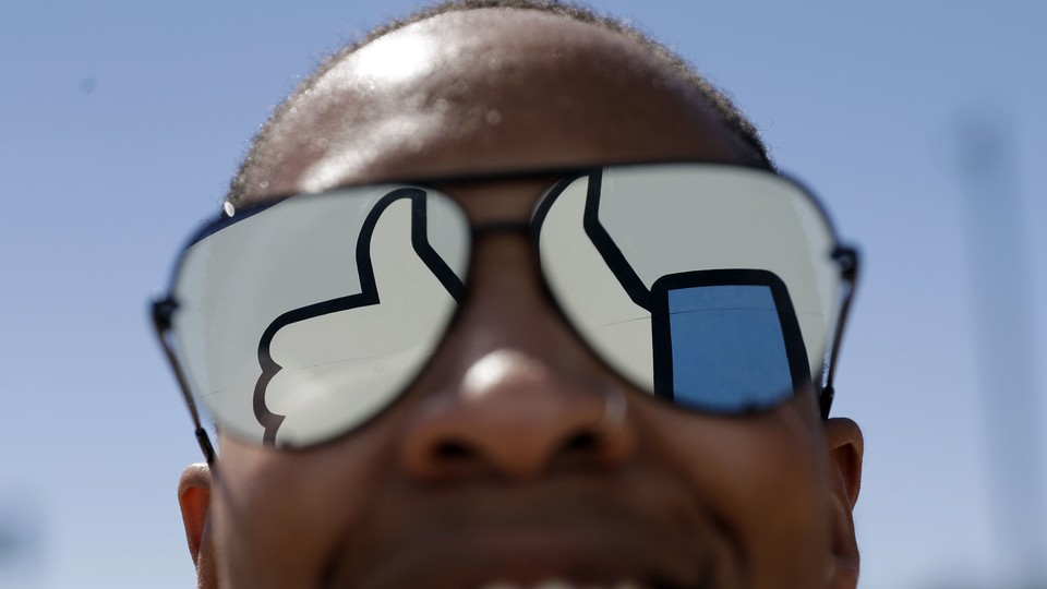The Facebook "like" symbol reflected in a person's sunglasses