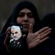 An Iranian woman displays an image of Qassem Soleimani on her phone.