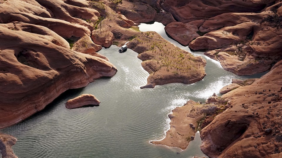 A low river flows at the bottom of a drought-stricken southwestern canyon.