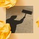 A black-and-white photo shows the shadow of a person holding up a protest sign.