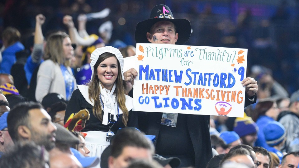Fans holds signs during the game between the Detroit Lions and the Minnesota Vikings on Thanksgiving at Ford Field