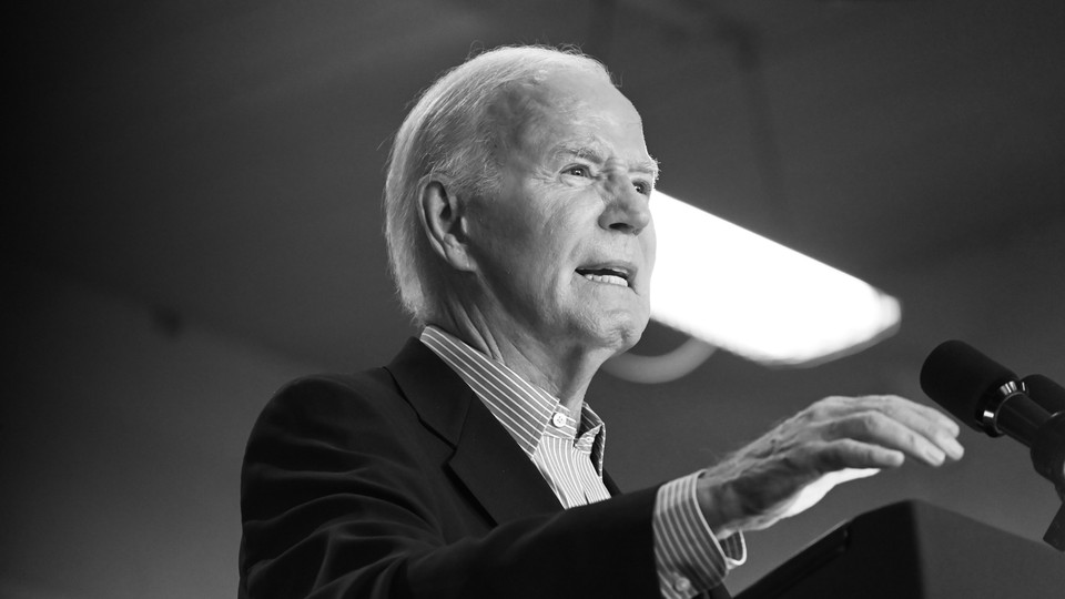 A black-and-white photo of Joe Biden speaking into a microphone at a rally in Madison, Wisconsin