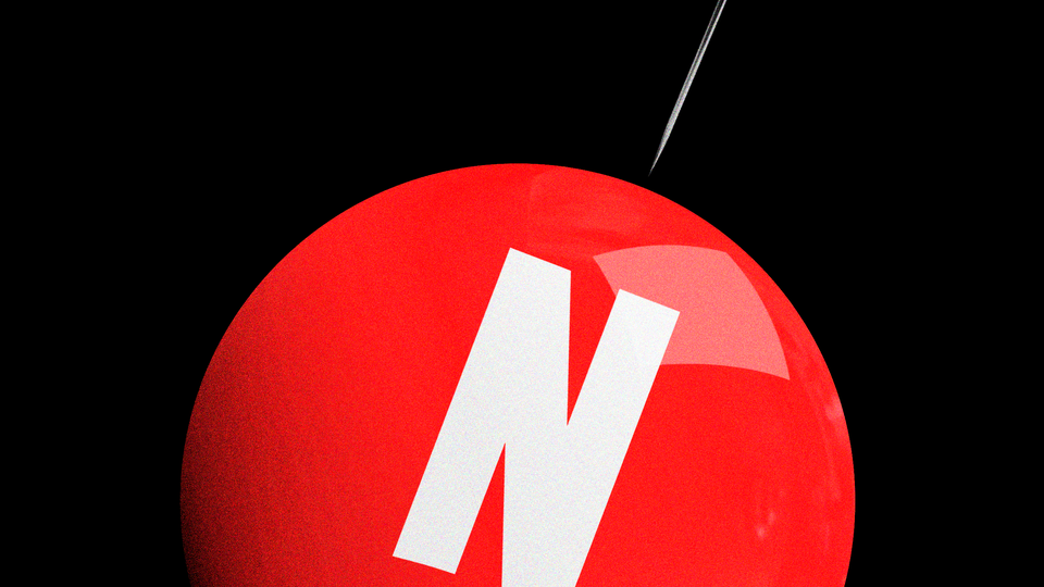 A red balloon with a white "N," with a needle pointing at it, against a black background