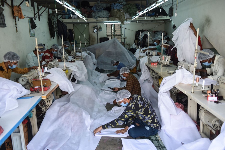 People work in a small factory on personal protective equipment.