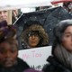 A woman holds a "Me Too" sign.