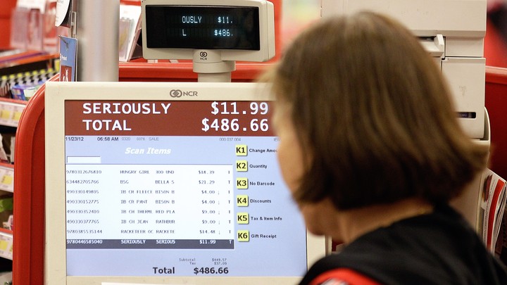 A cashier at a retail store looks at the cash register's screen.