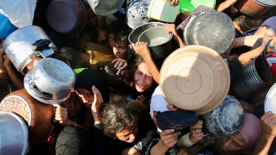 Palestinians scramble for aid at a food-distribution point.