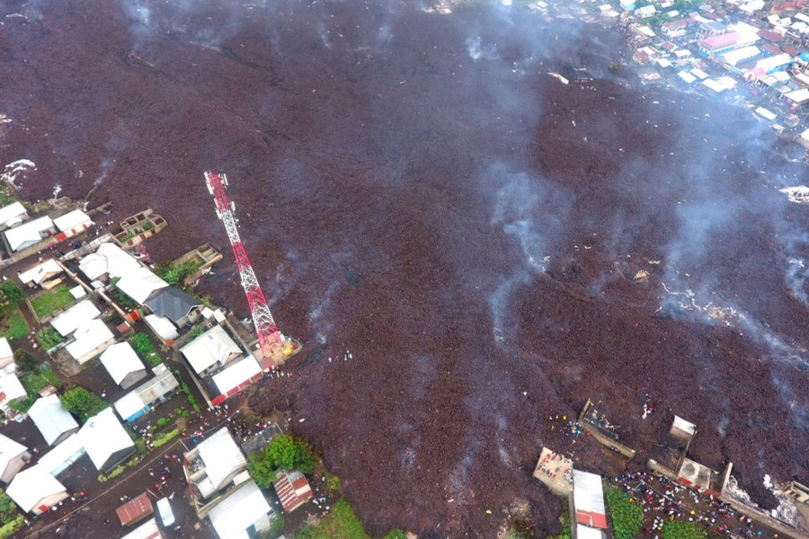 An aerial view of smoking lava flow amid a village