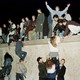 East German citizens climb the Berlin wall at the Brandenburg Gate as they celebrate the opening of the East German border on November 10, 1989.