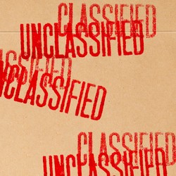 A brown folder with the words 'classified' and 'unclassified' stamped in red all over