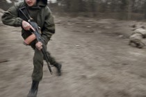 blurry image of a man running with a gun in combat gear