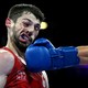 A boxer's contorted face, seen just after being punched hard, with his opponent's arm and glove below