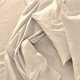 Bunched white bed sheets and two pillows