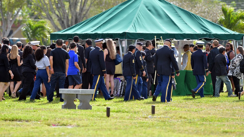 People are seen walking outside of a tent 