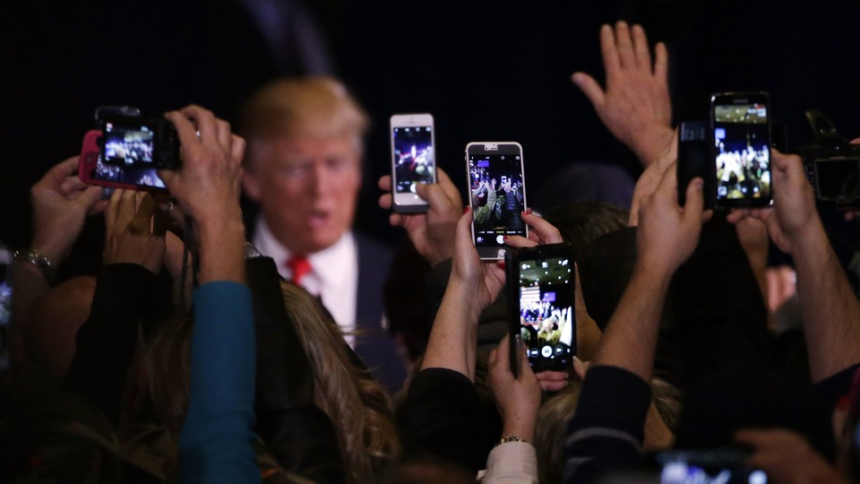 Donald Trump’s supporters take cell phone photographs of him during a February 2016 rally in Reno, Nevada.