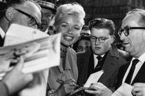 September 25, 1957; London, England, U.K. Jayne Mansfield signing autographs when she arrived at the Dorchester Hotel.