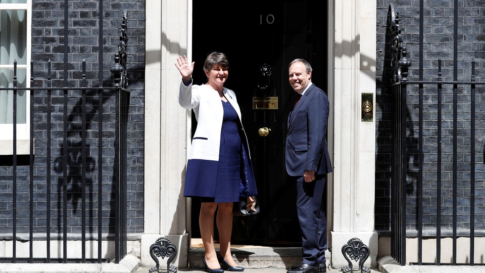The leader of the Democratic Unionist Party (DUP), Arlene Foster, and the Deputy Leader Nigel Dodds, stand on the steps of 10 Downing Street before talks with Britain's Prime Minister Theresa May on June 13, 2017.