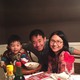 Xiyue Wang poses with his wife and young son at a dinner table.