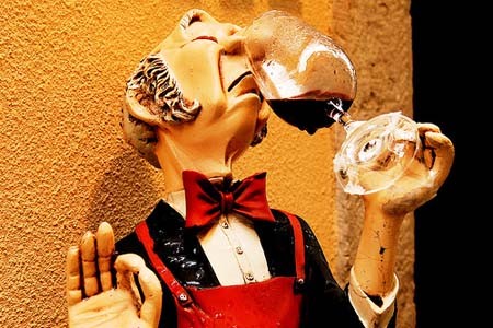Photo of a puppet smelling wine
