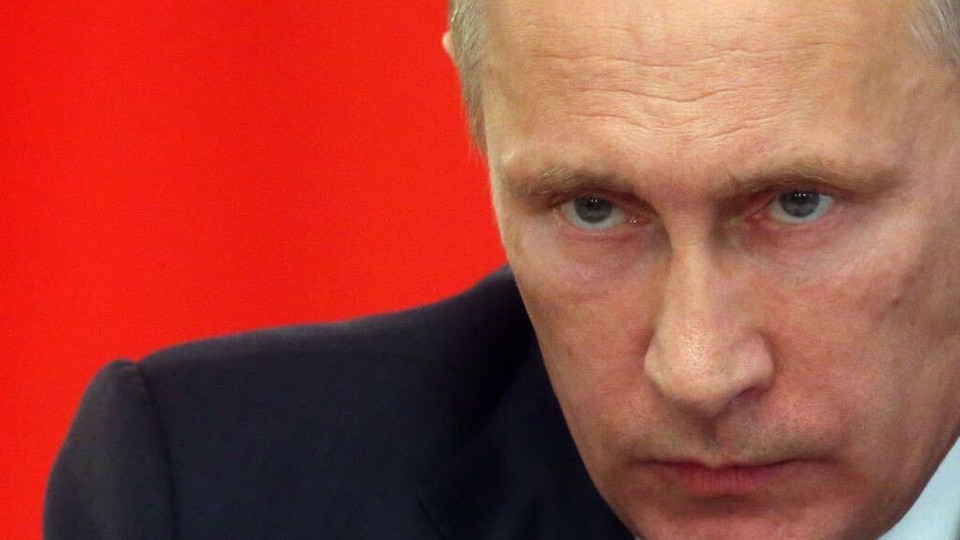 A close-up shot of Russian President Vladimir Putin's head and shoulder, against a red background