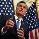 Mitt Romney stands in front of two American flags.