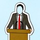A paper cutout of a suited man at a podium, whose face is cut out of the paper, on a light blue background