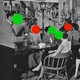 A black-and-white photograph of adults sitting around a restaurant table. Each person has either a red or green dot covering their face.
