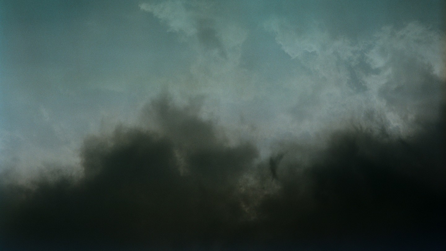 Moody photograph of a cloudy sky, half dark gray, half lighter blue