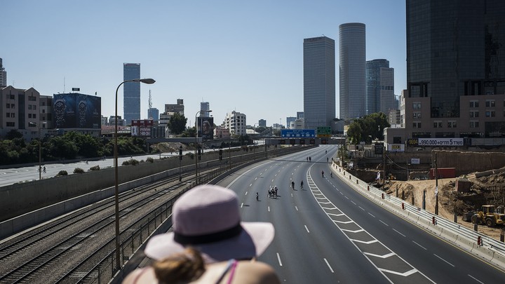 People ride their bicycles in the middle of the empty streets of Tel Aviv during Yom Kippur on October 04, 2014 in Tel Aviv, Israel.