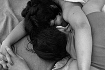 black and white photo of a tattooed couple laying on a beach towel