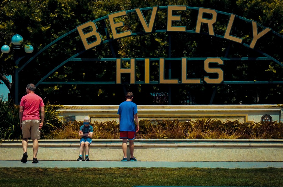 photo of several people in front of large 'BEVERLY HILLS' sign