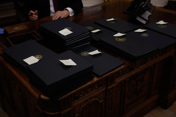 Multiple piles of executive orders on Donald Trump's desk