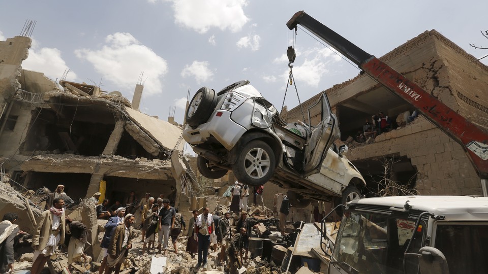 A car is lifted by a crane at the site of a Saudi-led air strike in Yemen's capital Sanaa.