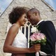 A bride and groom embrace outside a chapel.