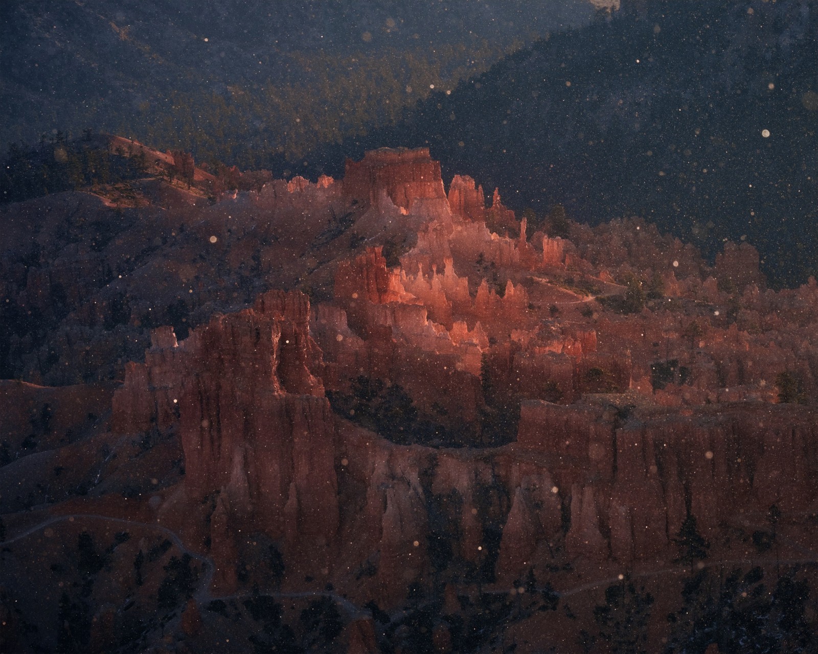 Spires of rock formations in Bryce Canyon, seen through falling snowflakes.