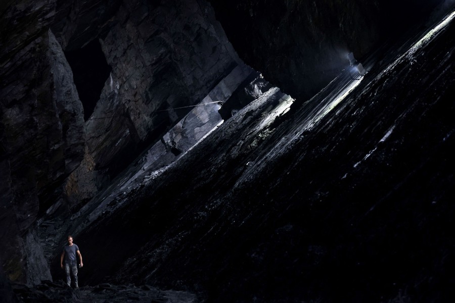 A man walks inside a cavernous mine.