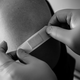 Black and white image of someone getting a band-aid after a shot