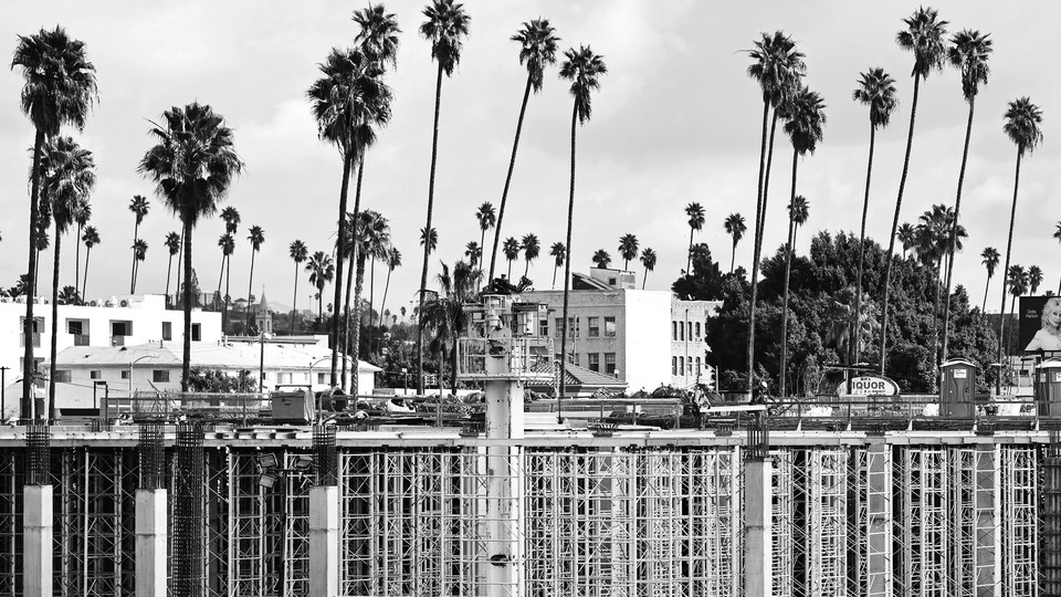 Construction workers help build a mixed-use apartment complex that will hold more than 700 units of apartment housing and 95,000 square feet of commercial space, on January 25, 2024, in Los Angeles, California.