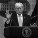 Black-and-white photo of Donald Trump speaking at a podium during a White House press conference.