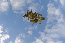 Dollar bills float against a blue sky