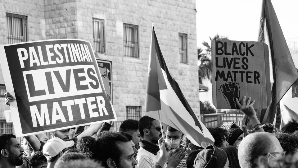 Protest signs reading "Palestinian lives matter" and "Black lives matter."