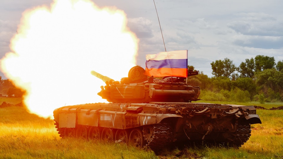 A Russian T-72 tank test-fires with a Russian flag atop it.