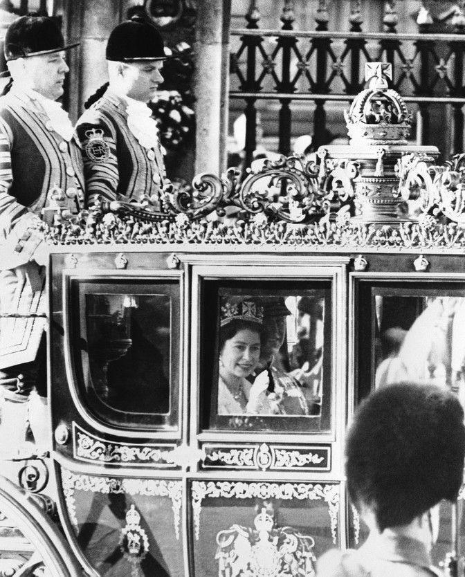 Queen Elizabeth II rides in a coach to Parliament to deliver the Queen's Speech.