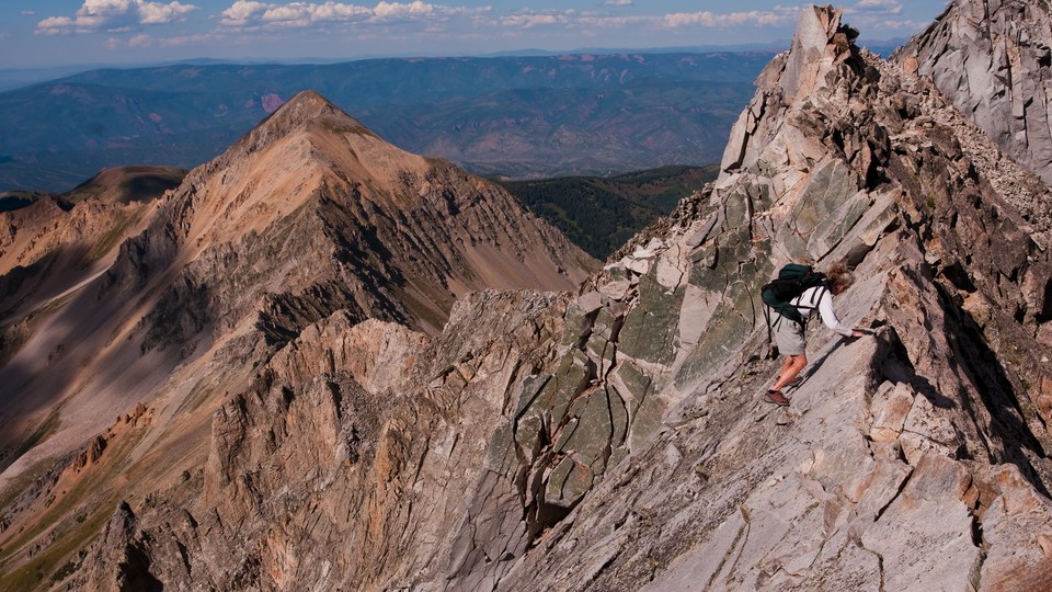 A woman climbing Capitol Peak's Knife Edge