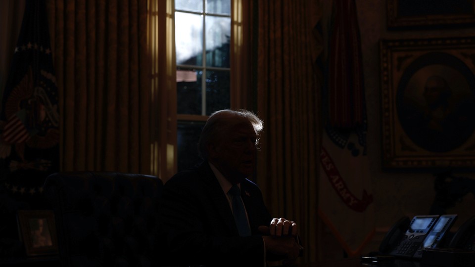 An image of Donald Trump sitting next to a window