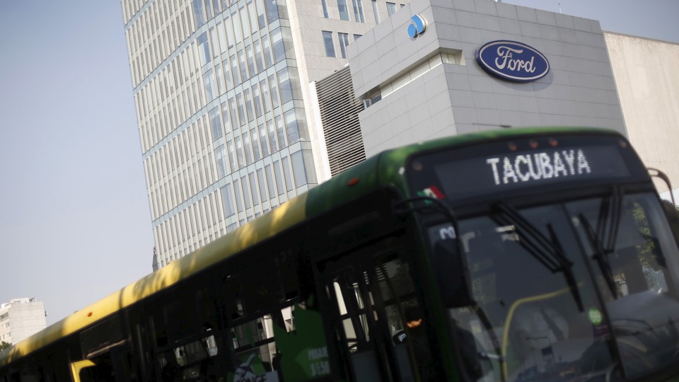 A bus passes in front of a Ford logo near a sales store of the automaker in Mexico City.