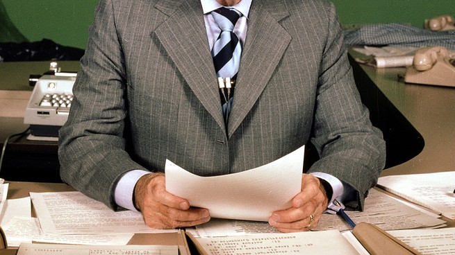 A newsreader before a microphone