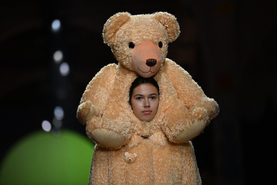 A model walks a runway wearing a furry outfit, with her "hood" being made of a large stuffed bear.